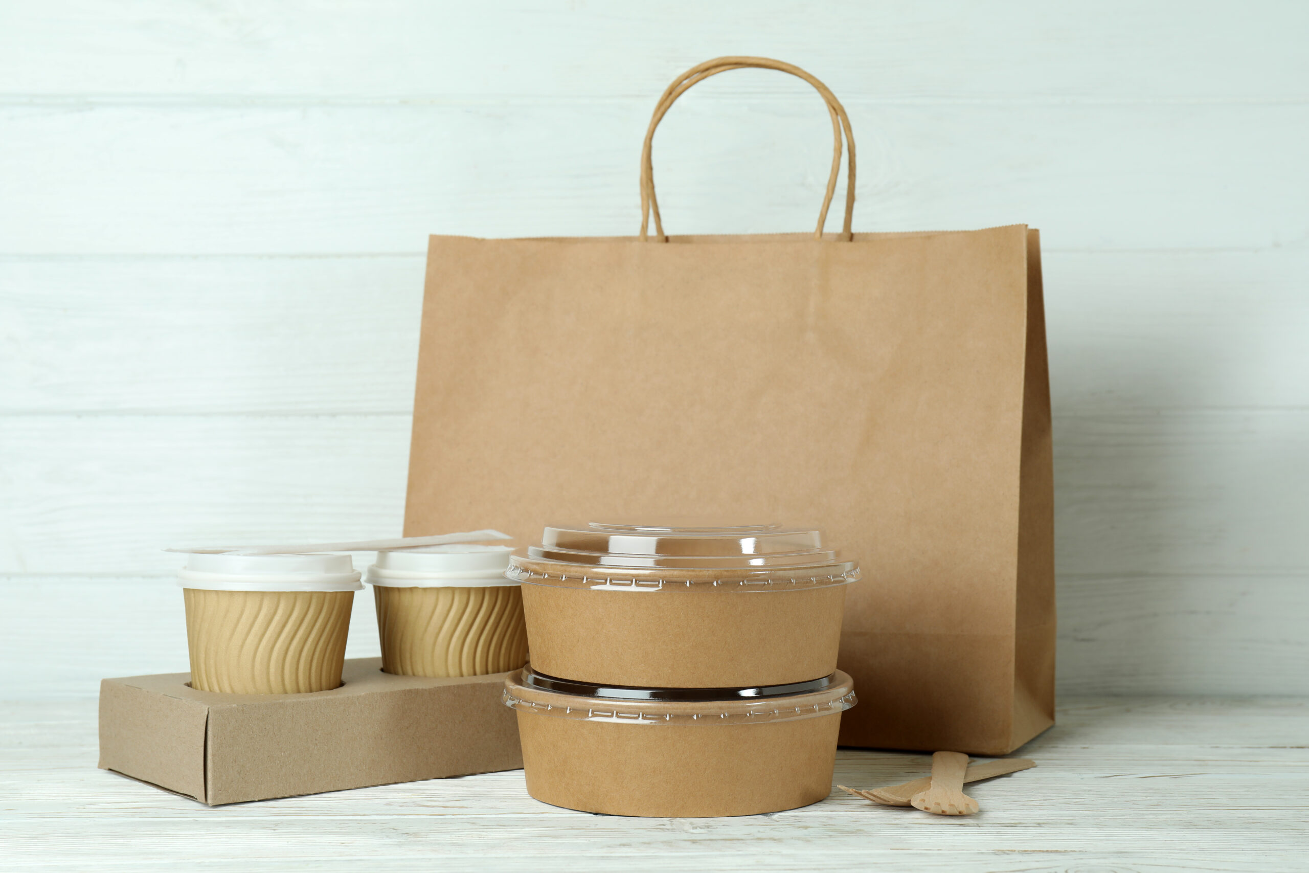 Delivery containers for takeaway food on white wooden table